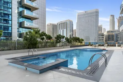 a large swimming pool in the middle of a city at Stylish 1BR Canal View & 12 min to Downtown in Dubai