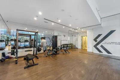 a man working out in a gym with weights at Stylish 1BR Canal View & 12 min to Downtown in Dubai