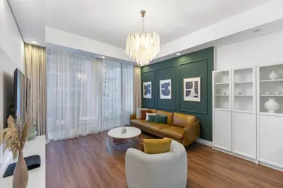 a living room with a couch and a chandelier at Stylish 1BR Canal View & 12 min to Downtown in Dubai