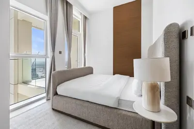 a bedroom with a bed and a chair and a window at Luxury Suite Huge Terrace Canal and Gevora Views with Infinity Pool in Dubai
