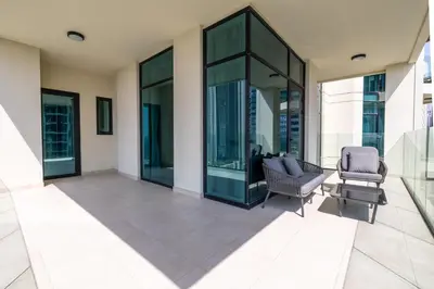a patio with two chairs and glass windows at Luxury Suite Huge Terrace Canal and Gevora Views with Infinity Pool in Dubai