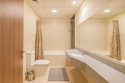 a bathroom with a toilet and a sink and a mirror at Spacious 1BR Apartment Imperial Residence B JVT in Dubai