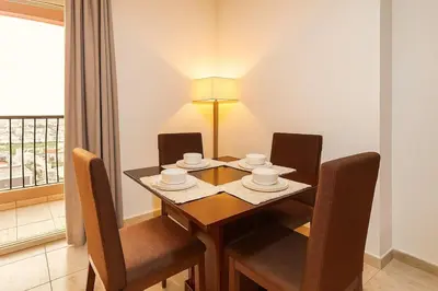 a dining room with a table and chairs and a window at Spacious 1BR Apartment Imperial Residence B JVT in Dubai