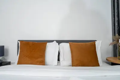 a bed with white pillows and a white headboard at Stylish Studio Retreat Heart of Downtown Dubai in Dubai