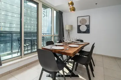 a dining room with a wooden table and black chairs at Spacious 2 Bedroom plus Office Prime Dubai Marina in Dubai