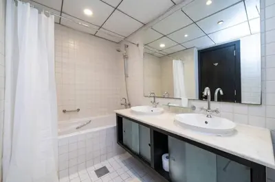a bathroom with two sinks and a tub and a mirror at Spacious 2 Bedroom plus Office Prime Dubai Marina in Dubai