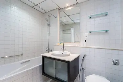 a bathroom with a sink and a mirror and a tub at Spacious 2 Bedroom plus Office Prime Dubai Marina in Dubai