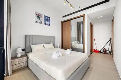 a bedroom with a large bed and a mirror at BLVD Luxe Stay with Pool Heart of JVC in Dubai