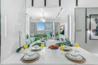 a living room with a table and glasses of orange juice at Iconic Burj Khalifa & Fountain Views near Dubai Mall in Dubai