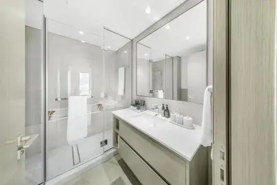 a white bathroom with a sink and a shower at Iconic Burj Khalifa & Fountain Views near Dubai Mall in Dubai