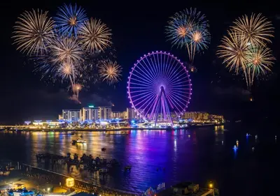 a ferris wheel with fireworks over a city at night at Luxurious 2BHK Sea & Dubai Eye View in Dubai