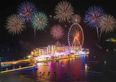 a fireworks display over a city with a ferris wheel at Luxurious 2BHK Sea & Dubai Eye View in Dubai