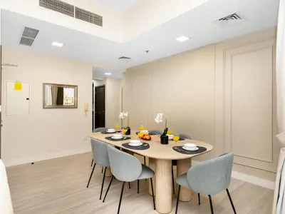 a dining room with a wooden table and chairs at Luxurious 2BHK Sea & Dubai Eye View in Dubai