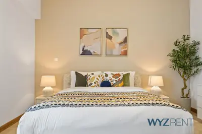 a bedroom with a white bed with two lamps at 2BR Aegean Charm Sulafa Tower, Canal View & Gym in Dubai