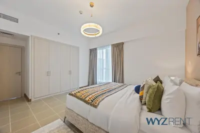 a bedroom with a large bed and a window at 2BR Aegean Charm Sulafa Tower, Canal View & Gym in Dubai