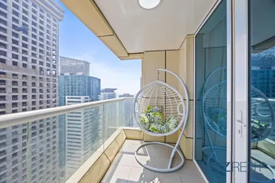 a balcony with a chair and a view of a city at 2BR Aegean Charm Sulafa Tower, Canal View & Gym in Dubai