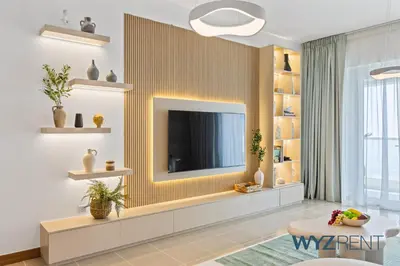 a living room with a television on a wall at 2BR Aegean Charm Sulafa Tower, Canal View & Gym in Dubai