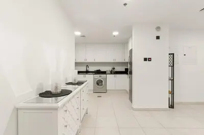 a kitchen with white cabinets and a washer and dryer at FIRST CLASS 1BR Luxury Marina Retreat in Dubai