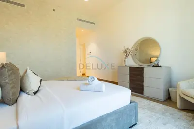 a bedroom with a large white bed and a mirror at Seafront 2BR, Within Walking Distance to La Mer Beach, Short Drive Away from Mercato Mall, La Sirene Building 2, La Mer by Deluxe Holiday Homes in Dubai