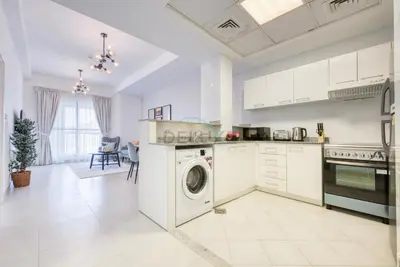 a white kitchen with a washing machine in it at Modern 1BR Retreat at Al Khail Heights, Al Quoz by Deluxe Holiday Homes in Dubai