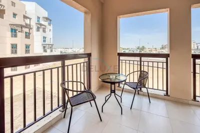 a room with two chairs and a table on a balcony at Modern 1BR Retreat at Al Khail Heights, Al Quoz by Deluxe Holiday Homes in Dubai