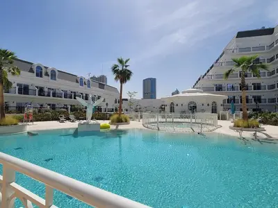 a large swimming pool in front of a building at Miracle Luxury Studio in Dubai