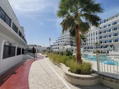 a palm tree on a walkway next to a building at Miracle Luxury Studio in Dubai