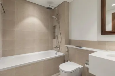 a bathroom with a tub and a toilet and a sink at Stylish 2BR Beachfront Pool&Gym Access in Dubai