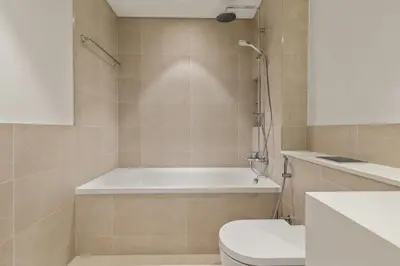 a bathroom with a bath tub and a toilet at Stylish 2BR Beachfront Pool&Gym Access in Dubai