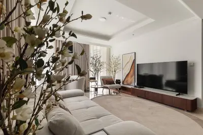 a living room with a couch and a flat screen tv at Stylish 2BR Beachfront Pool&Gym Access in Dubai