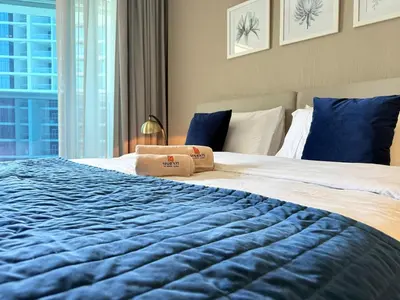 a bedroom with a large bed with a blue blanket at Mahenti · Luxury Living at Its Finest in Dubai