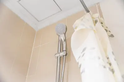 a shower head in a bathroom with a shower curtain at Prime Dubai Marina Spot - Beach, Dining and leisure in Dubai
