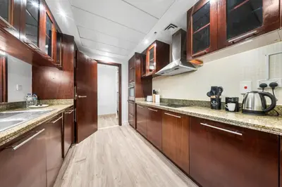 a large kitchen with wooden cabinets and a sink at Prime Dubai Marina Spot - Beach, Dining and leisure in Dubai