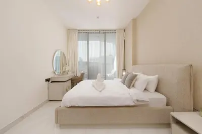 a bedroom with a large white bed with a window at Private Pool Stylish 1BR Arjan in Dubai