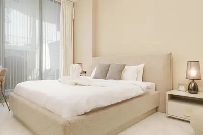 a bedroom with a large white bed with a window at Private Pool Stylish 1BR Arjan in Dubai