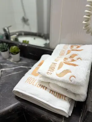 a pile of towels sitting on a counter in a bathroom at Luxury Stay - Walk to Dubai Mall & Burj Khalifa 21 in Dubai