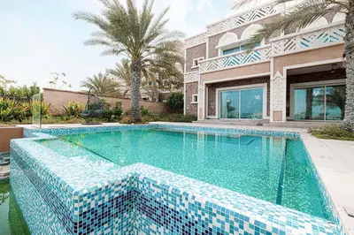 a swimming pool in front of a house at Villa with Private Pool in Palm Jumeirah in Dubai