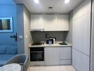 a small kitchen with white cabinets and a microwave at Zada Tower, Business Bay in Dubai