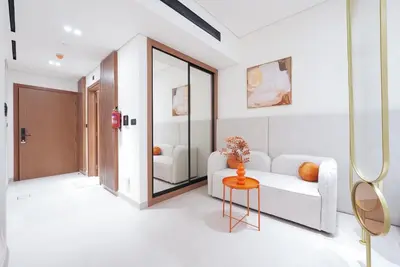 a living room with a white couch and a table at Designer Studio Retreat with Jacuzzi & Canal Views in Dubai