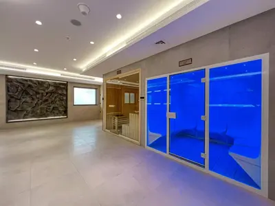 a large empty room with a large blue aquarium at Front Burj View - 6min to Dubai Mall - Pool - Gym in Dubai