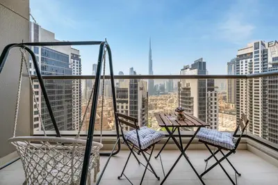 a balcony with two chairs and a table and a view at Front Burj View - 6min to Dubai Mall - Pool - Gym in Dubai