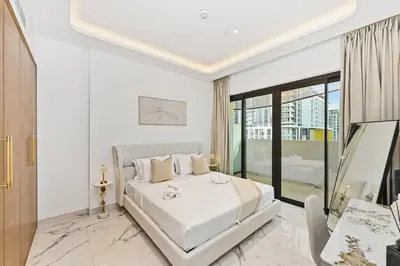 a white bedroom with a bed and a window at Riviera Azure Gateway Superior- 10min to Burj Khalifa, Dubai Mall and Airport and 20min to Marina in Dubai