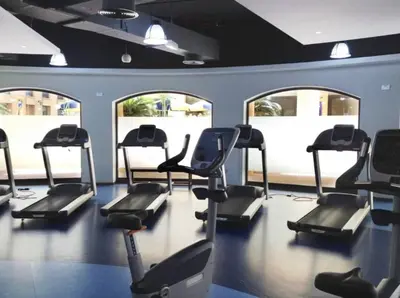 a gym with several treadmills in a room with windows at JBR - spacious and neat 3br apt in Shams 1 in Dubai