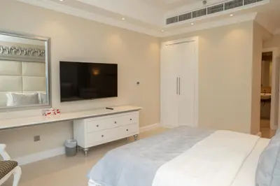 a white bedroom with a large bed and a television at BEACH FRONT I 2 Bedroom in TRIDENT JBR Dubai Marina I Palm & Sea Views I Amazing Balcony in Dubai