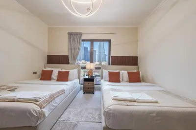 two beds in a room with a window at Theatre Room - Pool Access - Central 2br Apartment in Dubai