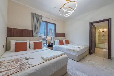 a bedroom with two beds and a large window at Theatre Room - Pool Access - Central 2br Apartment in Dubai