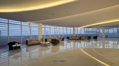 a lobby with couches and tables in a building at Luxury 1BR with 2 Balconies Dubai Science Park in Dubai