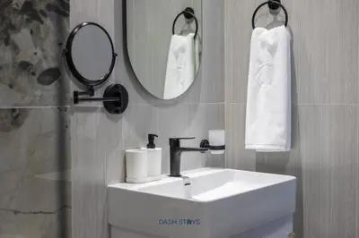 a bathroom with a sink and a mirror and towels at Luxury 1BR with 2 Balconies Dubai Science Park in Dubai