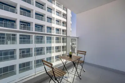 a table and chairs in front of a building at Luxury 1BR with 2 Balconies Dubai Science Park in Dubai