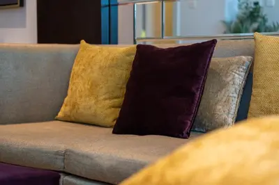 a couch with three pillows on it at Luxury 2 Bedroom Apartment DAMAC Uppercrest Downtown Near Dubai Mall in Dubai